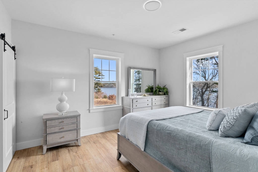 57 Long Point Road, Unit 210 Lakeville, MA 02347 - Photo 10 of 27 a bedroom with a bed and wooden floor