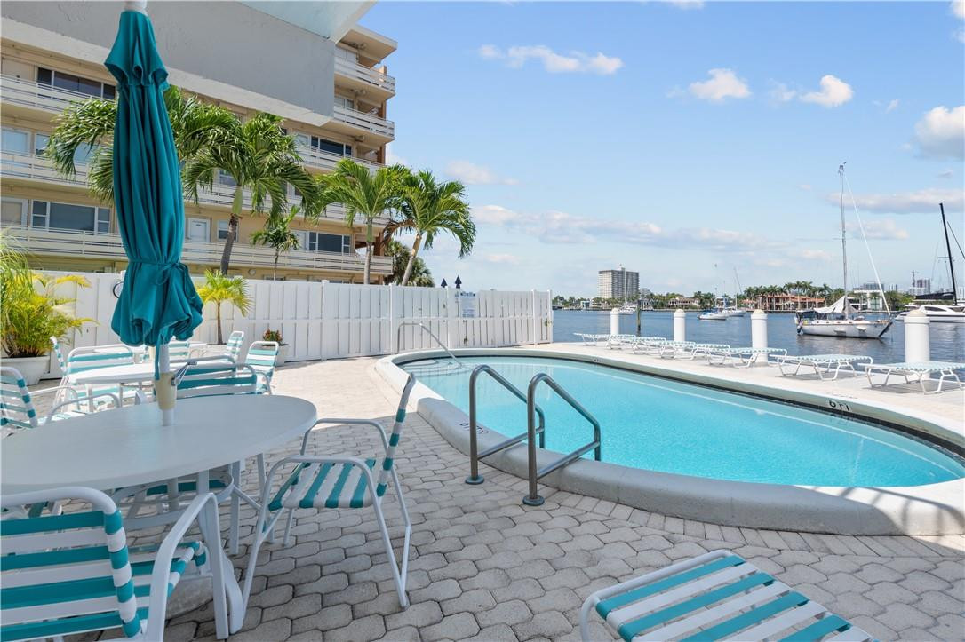 95 North Birch Road, Unit 405 Fort Lauderdale, FL 33304 - Photo 26 of 34 a view of a swimming pool with a patio and a yard