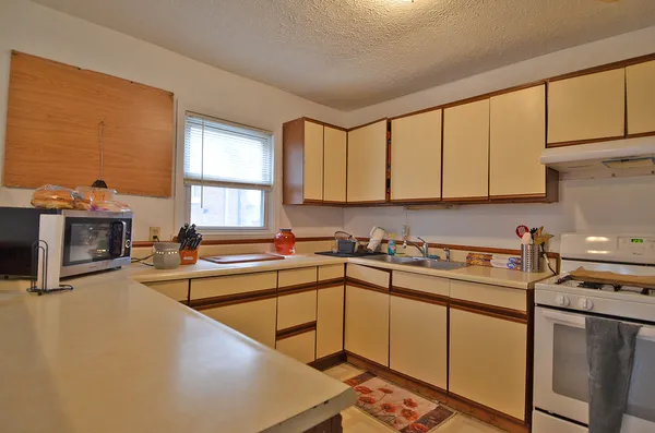 a kitchen with a sink a stove and cabinets