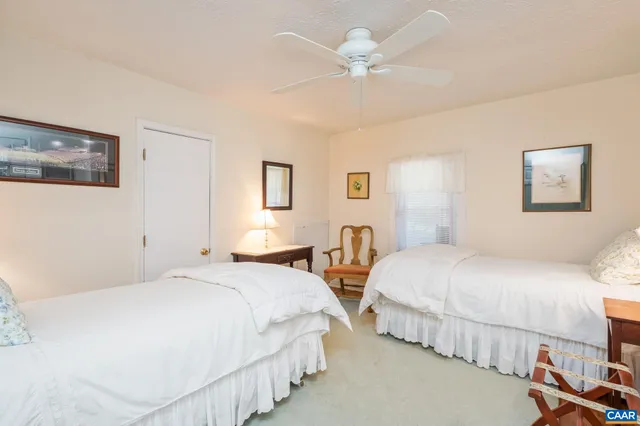 a bedroom with two beds and painting on the wall