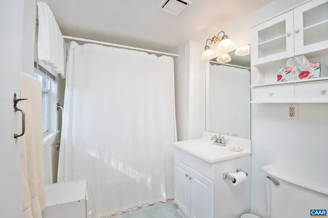 a bathroom with a sink mirror and shower