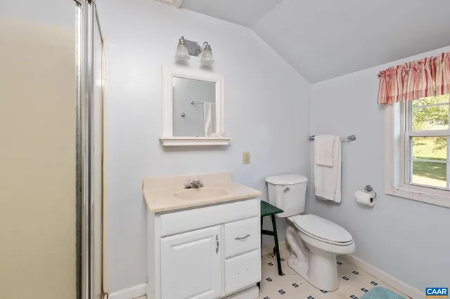 a bathroom with a toilet sink vanity and mirror