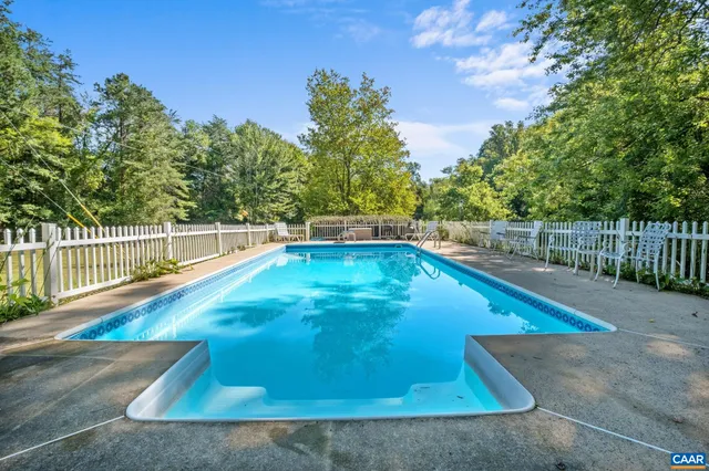 a view of a tennis ground with large trees