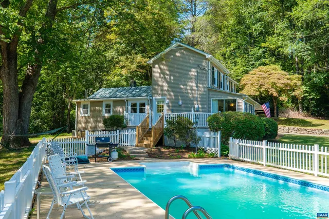 a view of a house with swimming pool and porch with furniture