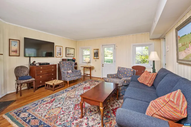 a living room with furniture flat screen tv and a large window