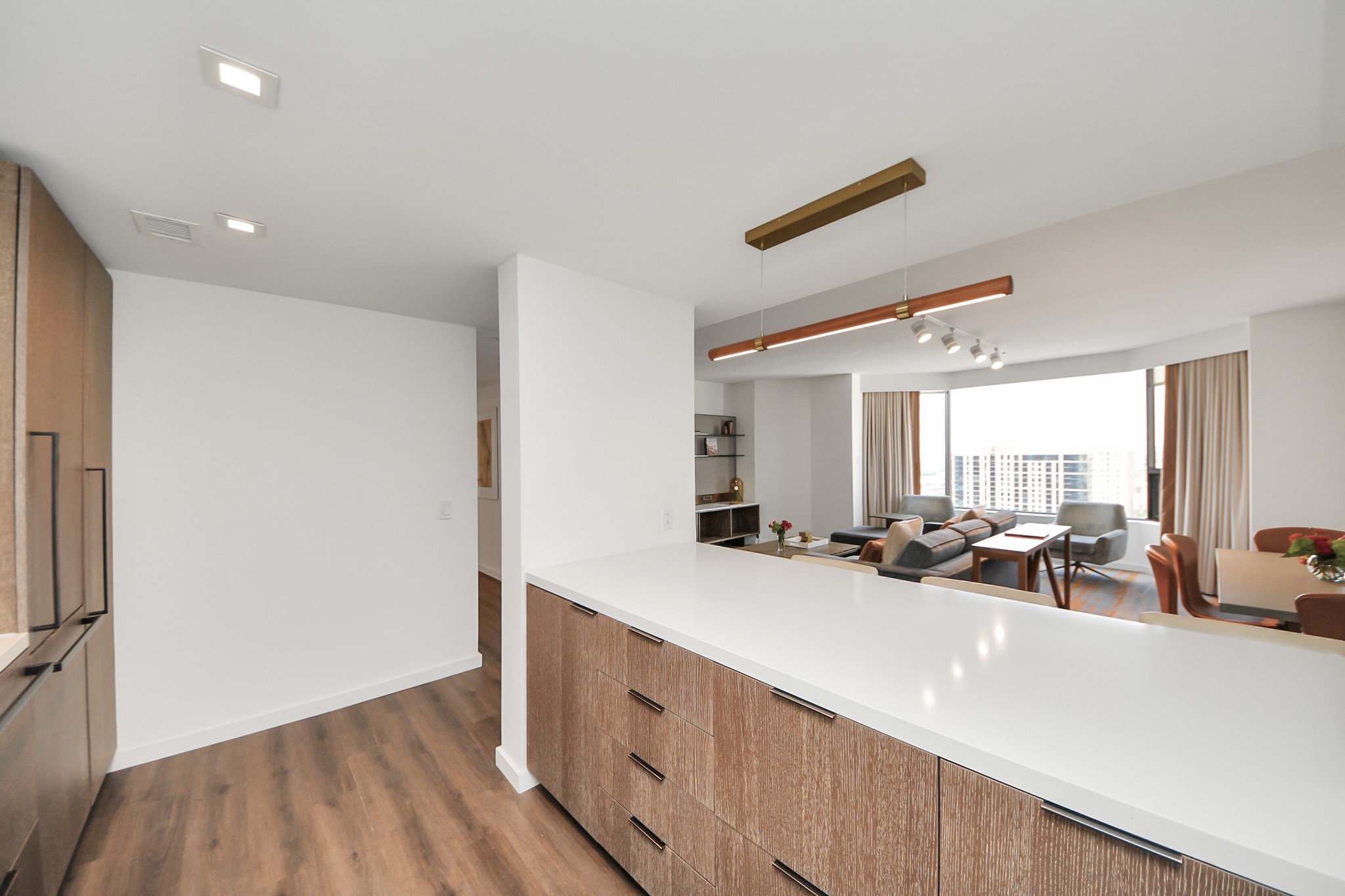 a view of a kitchen with kitchen island a counter top space a sink and a refrigerator
