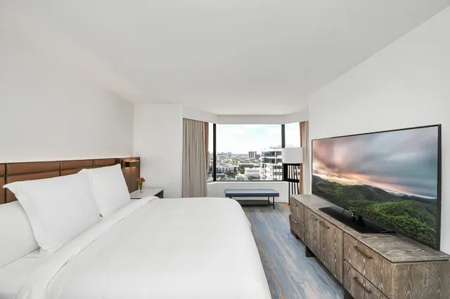 a large bedroom with a bed and a flat screen tv