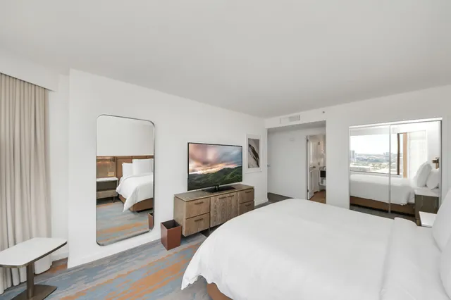 a spacious bedroom with a bed and a flat screen tv