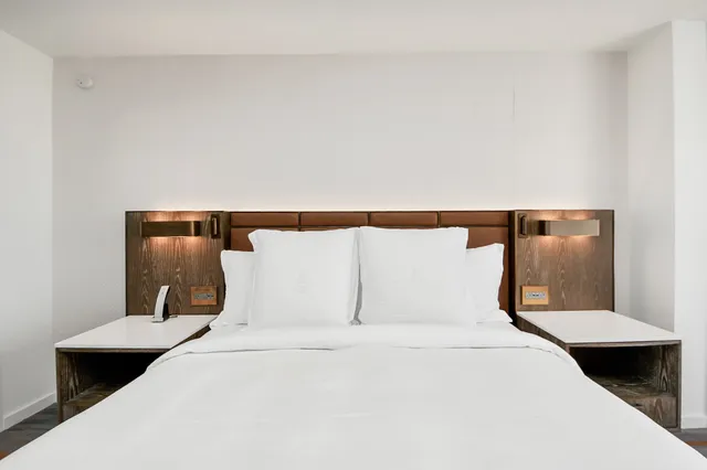 a bedroom with a large bed and wooden floor