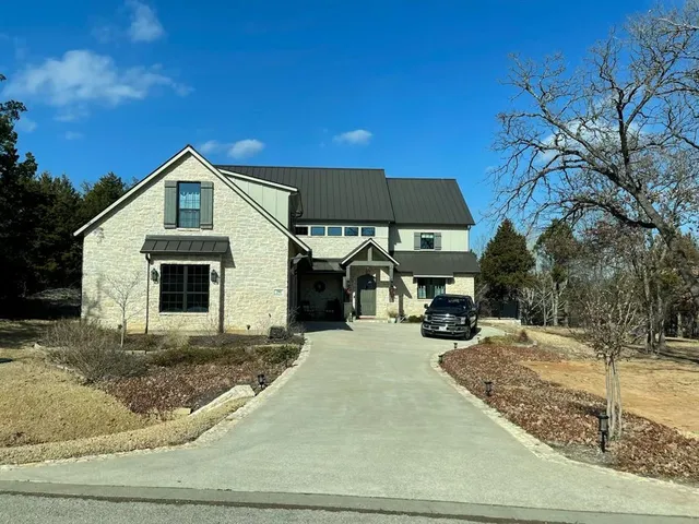 a view of a yard in front of a house with large trees