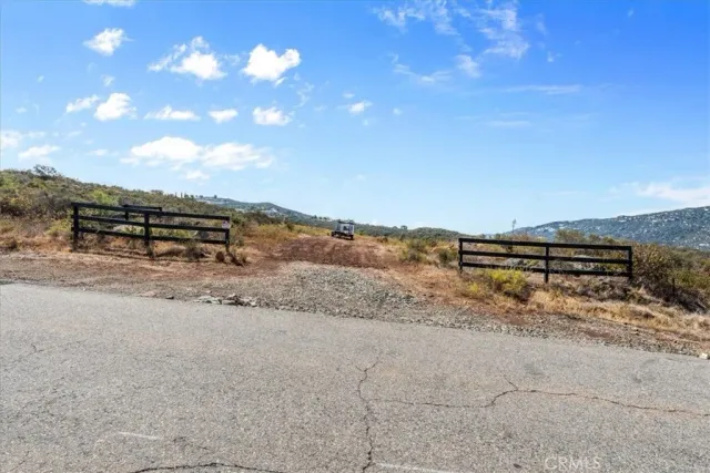 a view of a dry yard with wooden fence