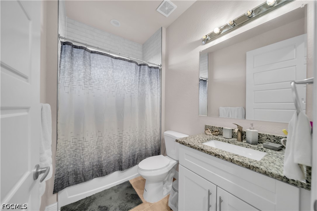 384 Neighborly Road LaBelle, FL 33935 - Photo 18 of 45 a bathroom with a granite countertop sink toilet and shower