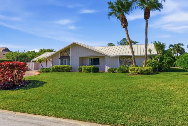 a view of a house with a yard and a palm tree