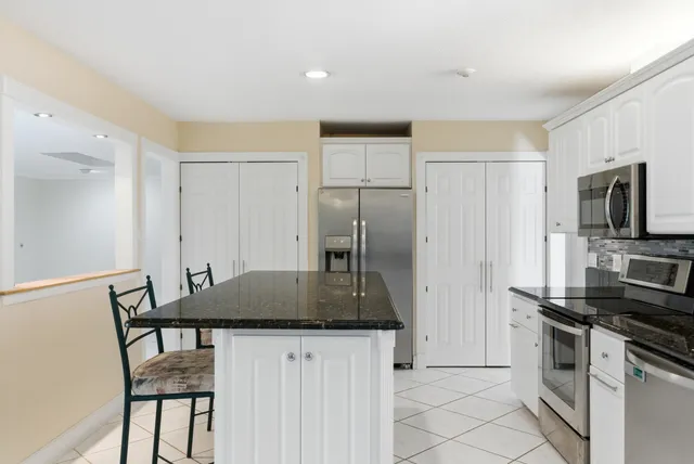 a kitchen with granite countertop a sink and cabinets