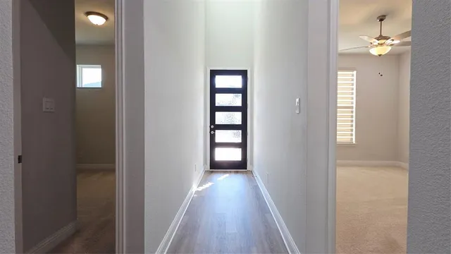 a view of a hallway with wooden floor and closet