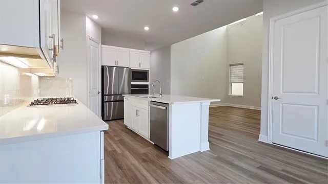 a kitchen with wooden cabinets and stainless steel appliances