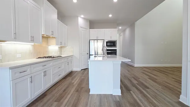 a kitchen with kitchen island granite countertop wooden cabinets and white appliances