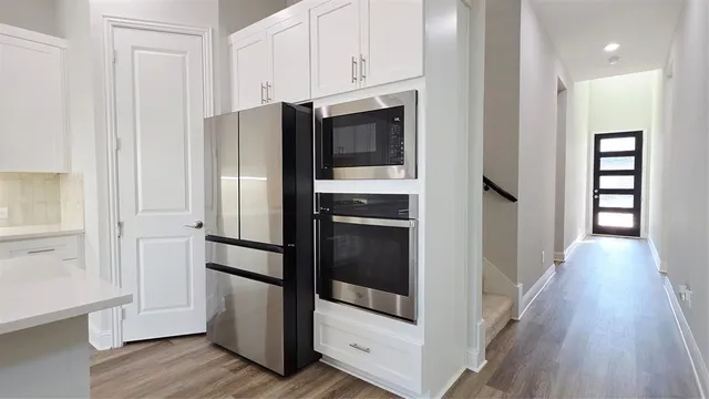 a kitchen with a refrigerator and wooden floor
