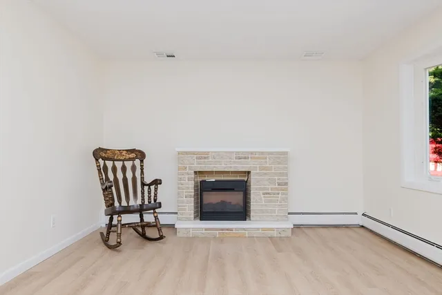 a view of a livingroom with wooden floor and a fireplace