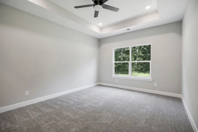 an empty room with a ceiling fan and window