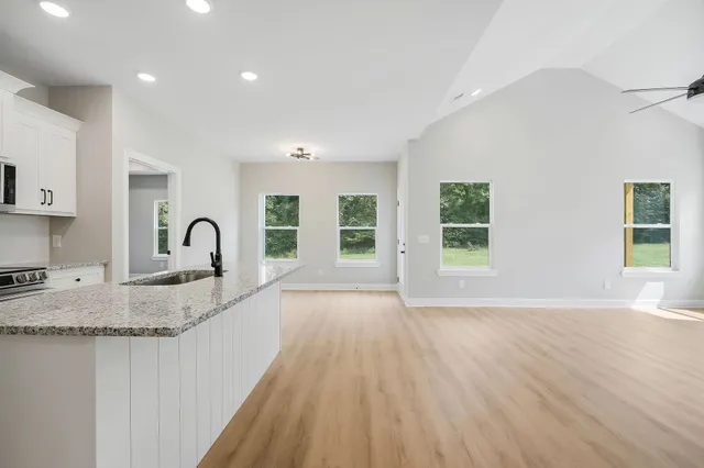 a view of a kitchen with sink and dishwasher with wooden floor