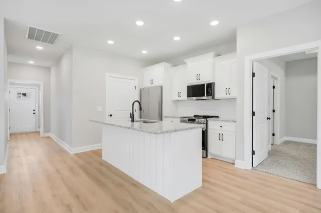 a kitchen with stainless steel appliances a sink stove and refrigerator