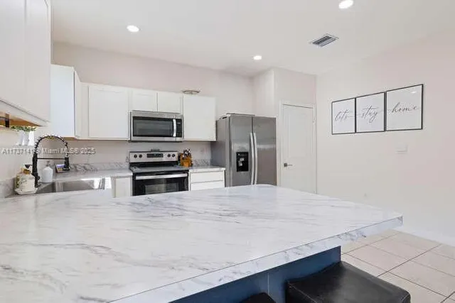 a kitchen with stainless steel appliances a refrigerator and a stove top oven