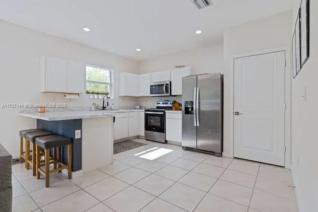a kitchen with stainless steel appliances granite countertop a refrigerator and a stove top oven