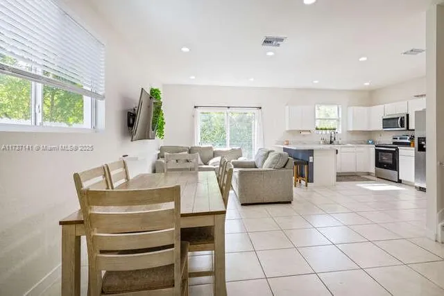 a living room with granite countertop furniture a flat screen tv and windows