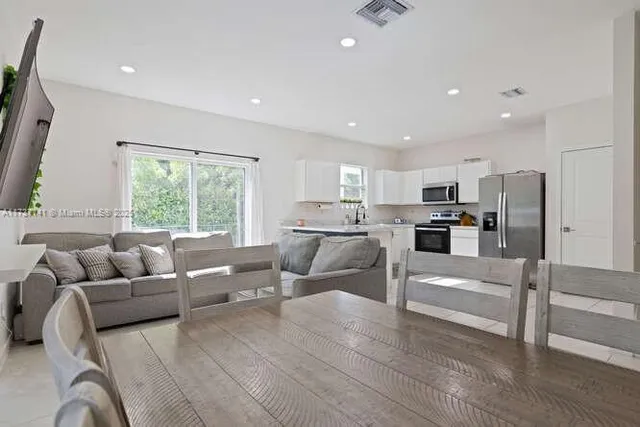 a living room with furniture and kitchen view