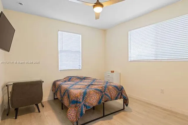 a bedroom with a bed a chair and a potted plant