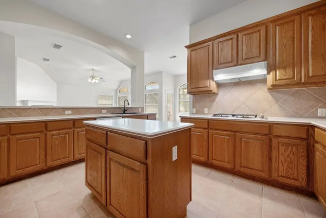 a kitchen with kitchen island granite countertop a sink stainless steel appliances and cabinets