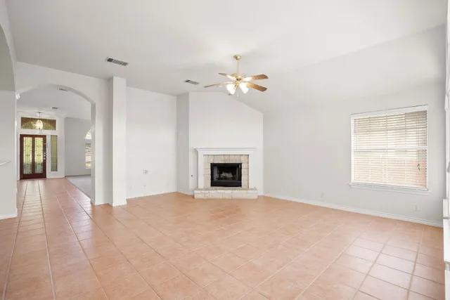 a view of an empty room with a fireplace and a window