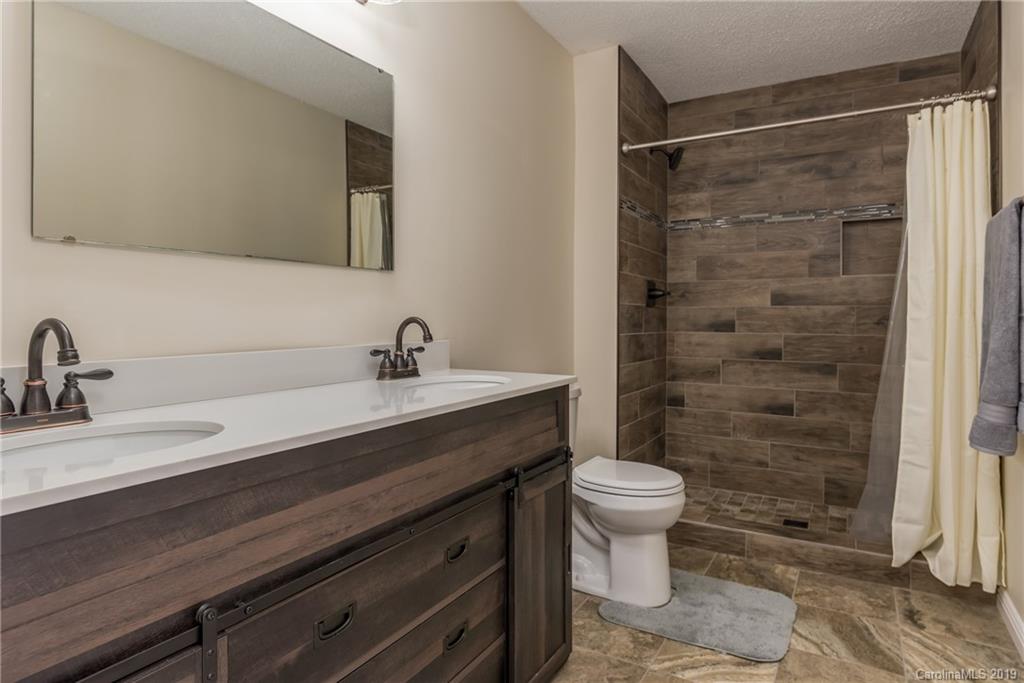 1014 South Main Street Rutherfordton, NC 28139 - Photo 7 of 31 a bathroom with a sink a toilet a shower and a mirror