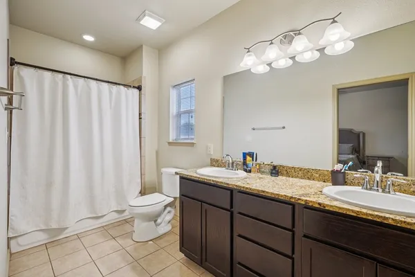 a bathroom with a double vanity sink mirror and toilet