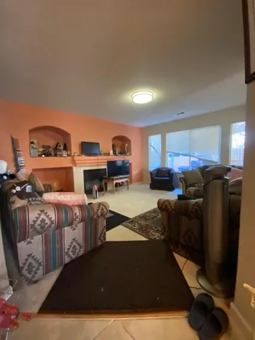 a living room with furniture a flat screen tv and kitchen view