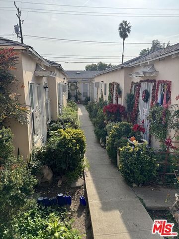 a front view of a house with a yard and potted plants