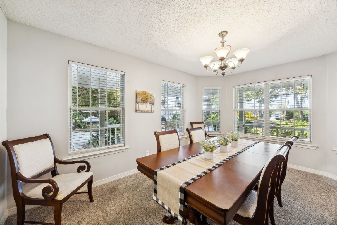 97535 Pirates Point Road Yulee, FL 32097 - Photo 12 of 59 a view of a dining room with furniture a chandelier and wooden floor
