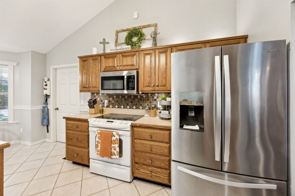 97535 Pirates Point Road Yulee, FL 32097 - Photo 23 of 59 a kitchen with stainless steel appliances a stove microwave and a refrigerator