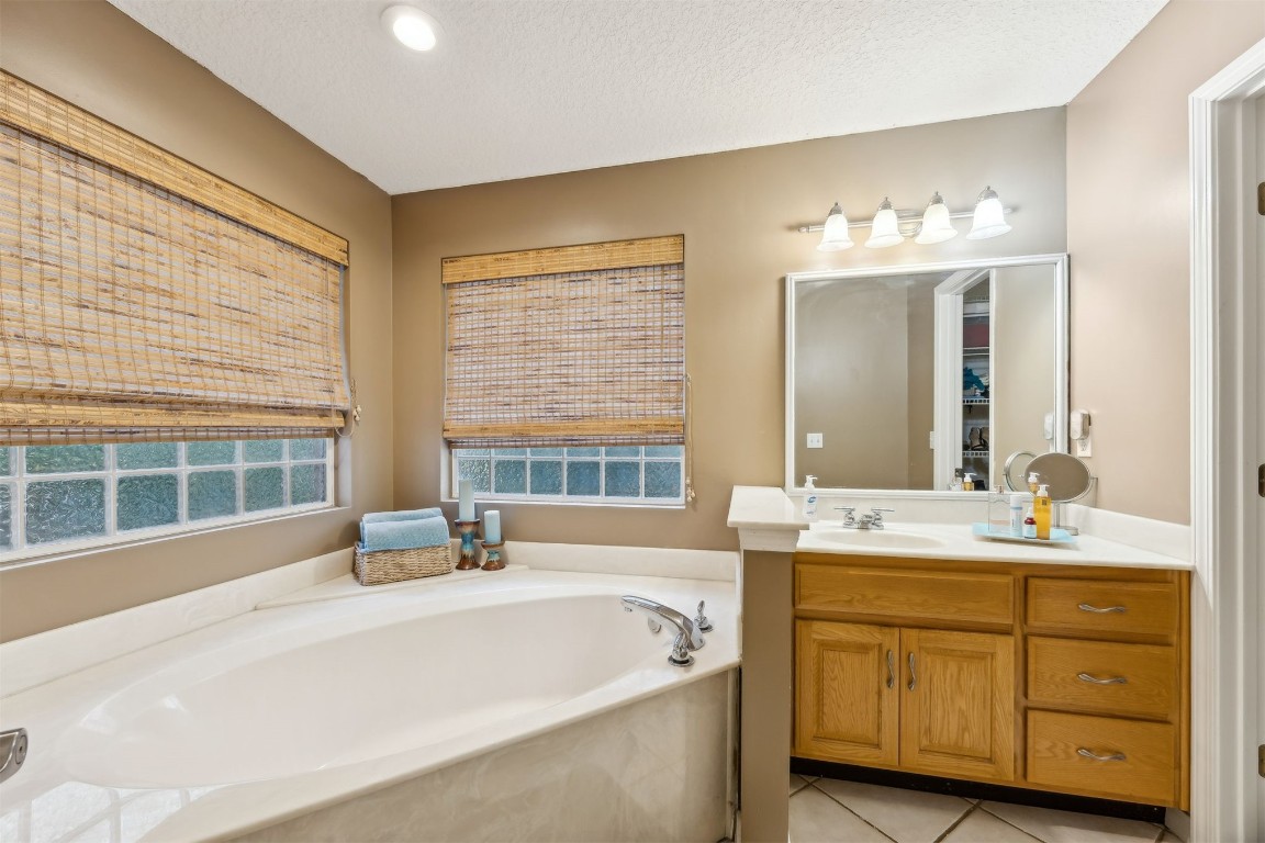 97535 Pirates Point Road Yulee, FL 32097 - Photo 29 of 59 a bathroom with a tub double sink window and mirror