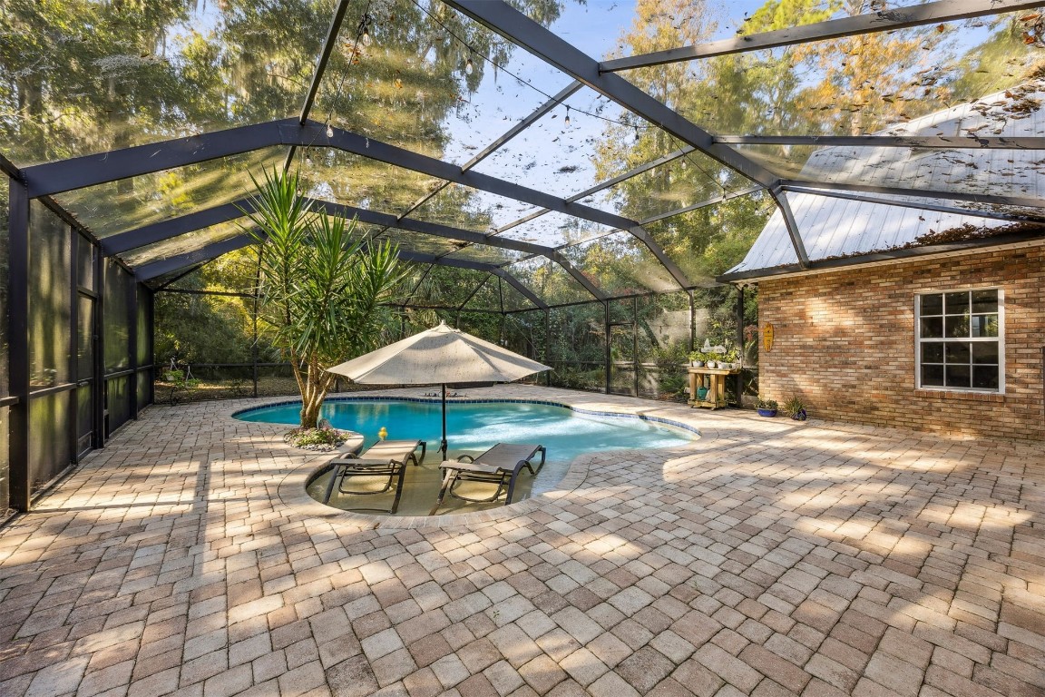 97535 Pirates Point Road Yulee, FL 32097 - Photo 41 of 59 a view of a patio with a table and chairs under an umbrella