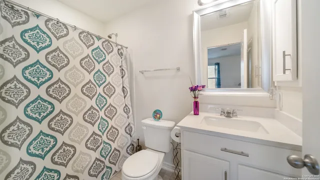 a bathroom with a sink mirror vanity and toilet
