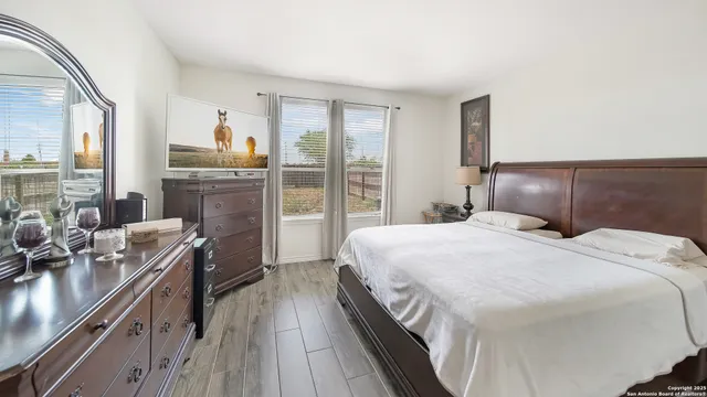 a bedroom with a bed and a large mirror next to a large window