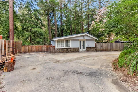 a view of a house with a yard and wooden fence