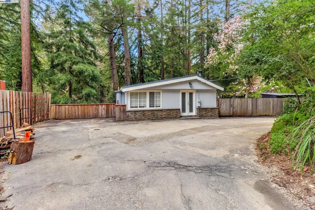 a view of a house with a yard and wooden fence