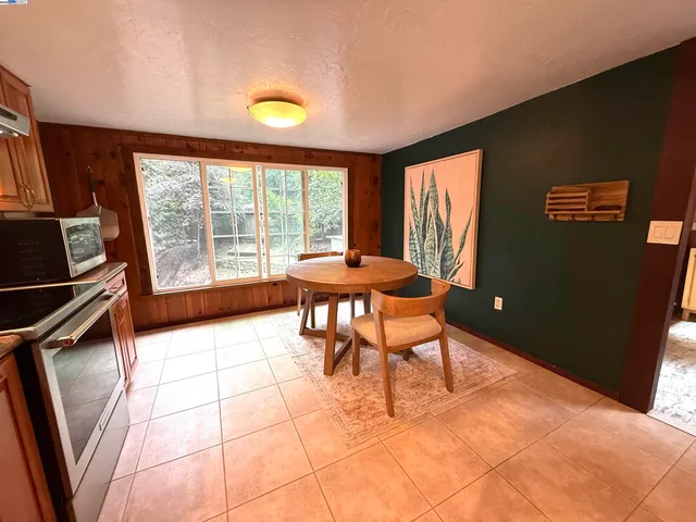 a dining room with furniture and a floor to ceiling window