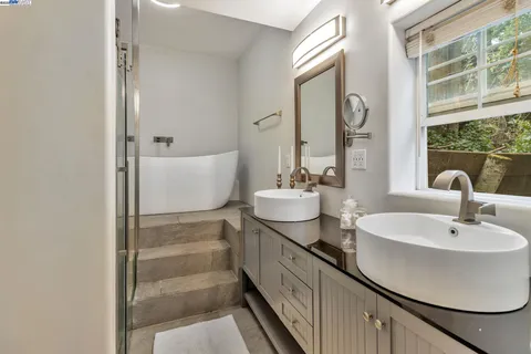 a bathroom with double sink and a mirror