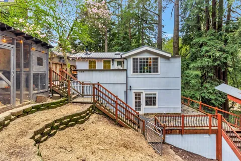 a view of a house with a small yard and wooden deck
