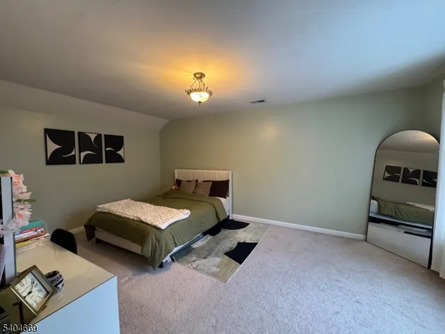a bedroom with two beds and a lamp