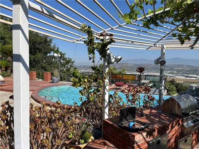 a view of a swimming pool with a patio and couches chairs